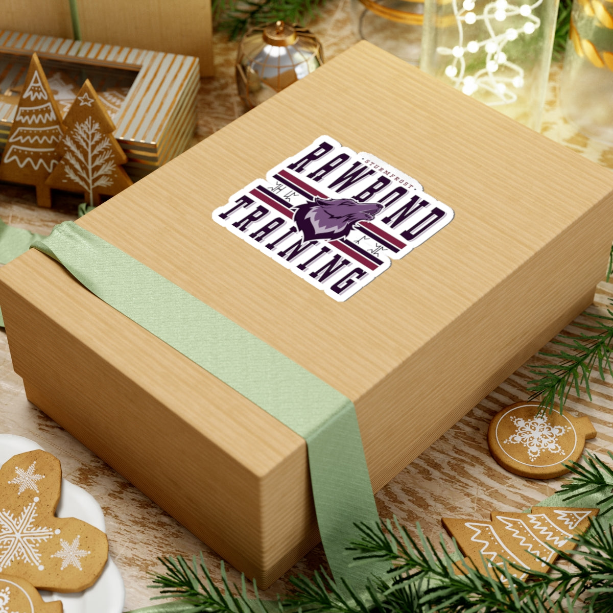 A Rawbond Training Sticker from the Wolves of Ruin collection by thtgrlreads featuring bold text and wolf graphic, displayed on a festive gift box surrounded by holiday decor.