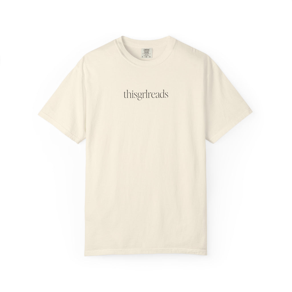 Thtgrlreads bookish apparel featuring a vintage wash Comfort Colors cream graphic tee with minimalist black serif text "thisgrlreads," part of the Tees and Book Bestie collections.