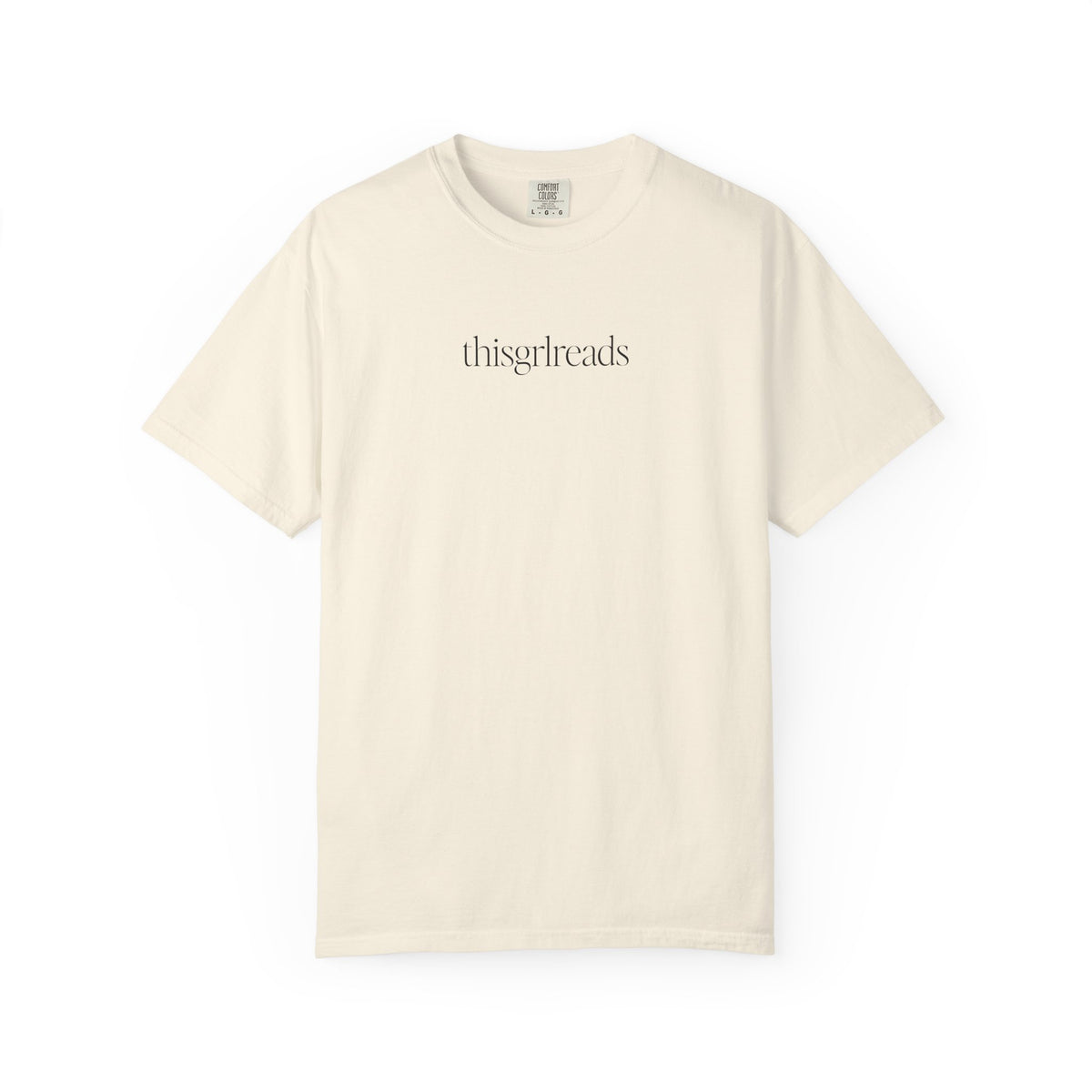 Thtgrlreads bookish apparel featuring a vintage wash Comfort Colors cream graphic tee with minimalist black serif text "thisgrlreads," part of the Tees and Book Bestie collections.