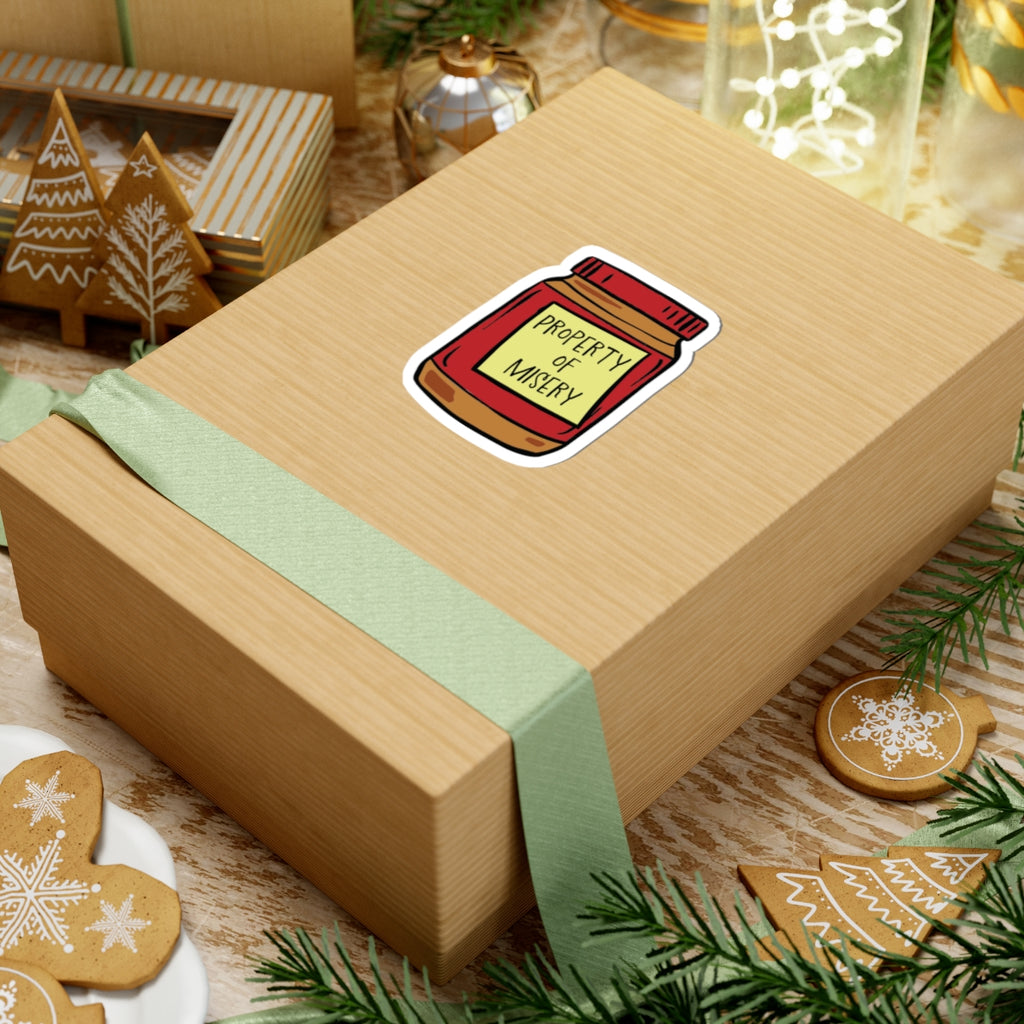 Thtgrlreads Ali Hazelwood sticker featuring a jar labeled Property of Misery on a wrapped holiday gift box, from the Stickers collection