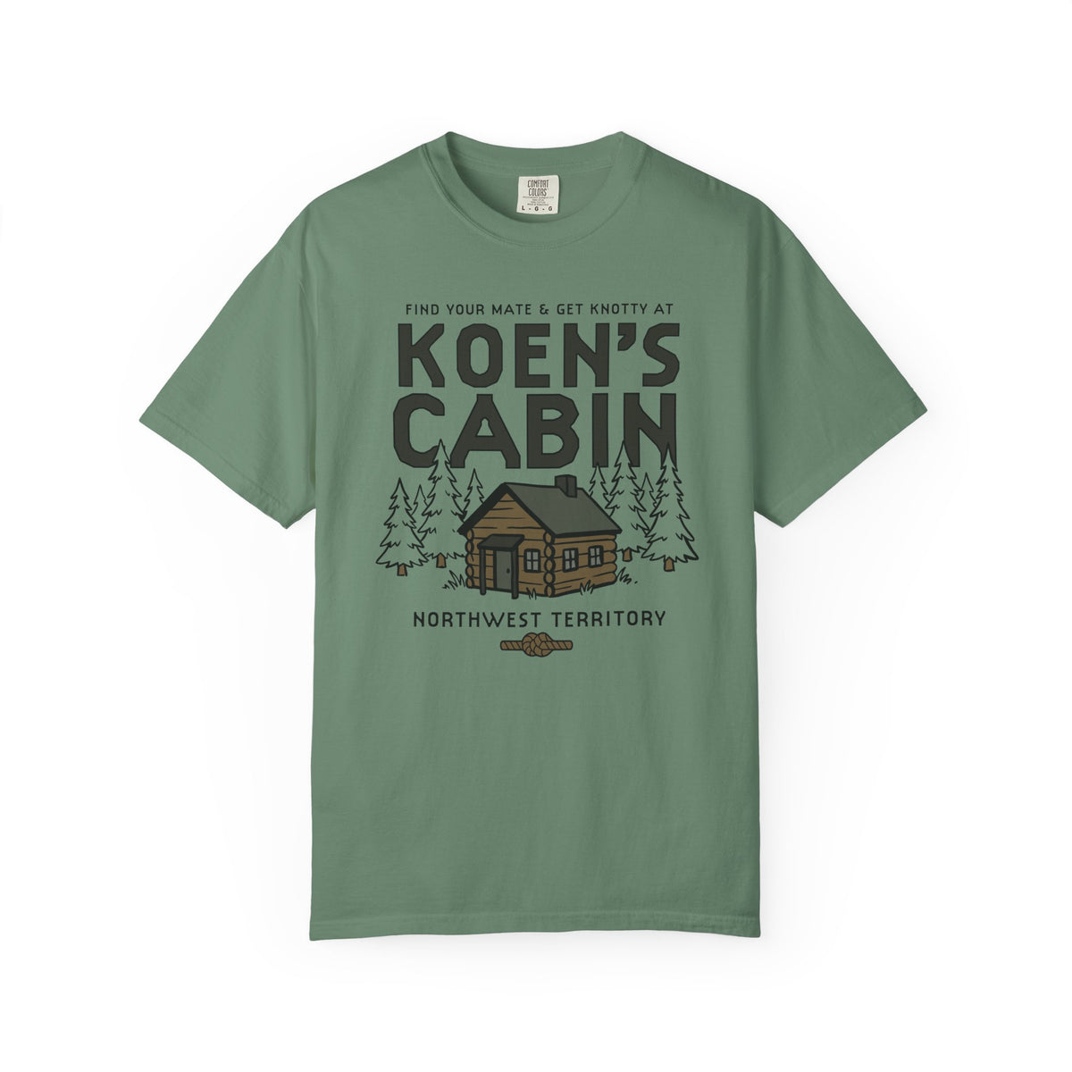 Green Comfort Colors graphic tee featuring Koen's Cabin lettering, a woodland cabin, pine trees, and Northwest Territory text from Thtgrlreads in Tees and Ali Hazelwood