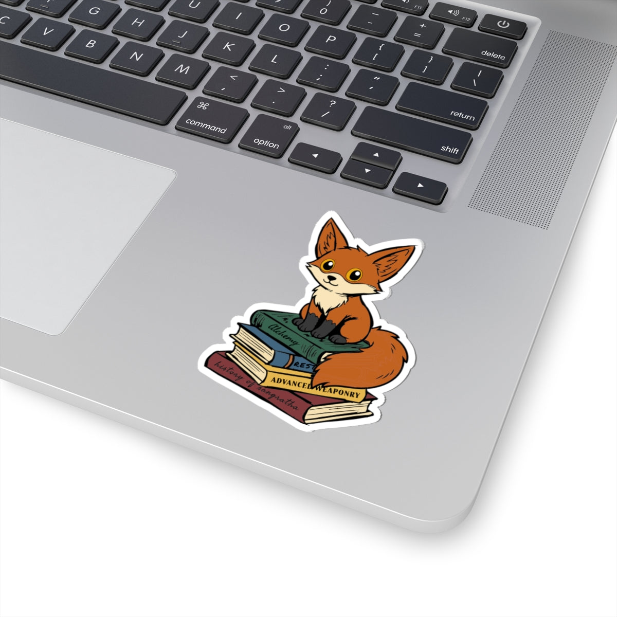 A cute Neville fox sticker from Bloodwing Academy collection by thtgrlreads, showing an illustrated fox sitting atop stacked books, perfect for laptops or notebooks.