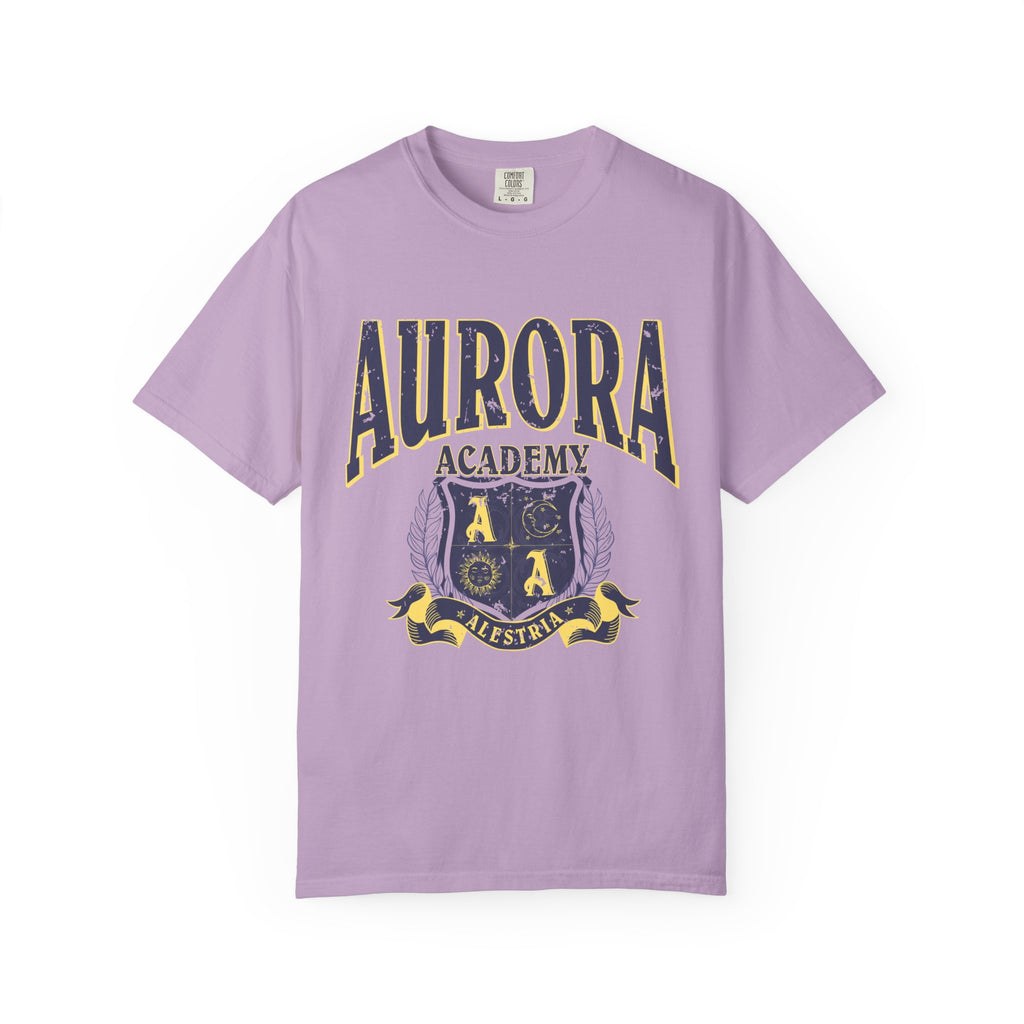 A vintage wash lilac Comfort Colors graphic tee from thtgrlreads featuring a distressed print of Aurora Academy with a crest emblem, part of the Ruthless Boys of the Zodiac and Back to School collections.