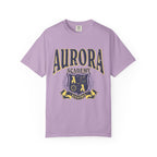 A vintage wash lilac Comfort Colors graphic tee from thtgrlreads featuring a distressed print of Aurora Academy with a crest emblem, part of the Ruthless Boys of the Zodiac and Back to School collections.