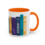 White ceramic mug with an orange handle and interior, featuring a colorful graphic of book spines labeled "Introverted" and "Scholars," designed by thtgrlreads for book lovers.