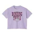 thtgrlreads Wolves of Ruin collection features a lavender Comfort Colors crop top with vintage wash, bold maroon "The Bonding Trials" text, and a detailed wolf graphic.