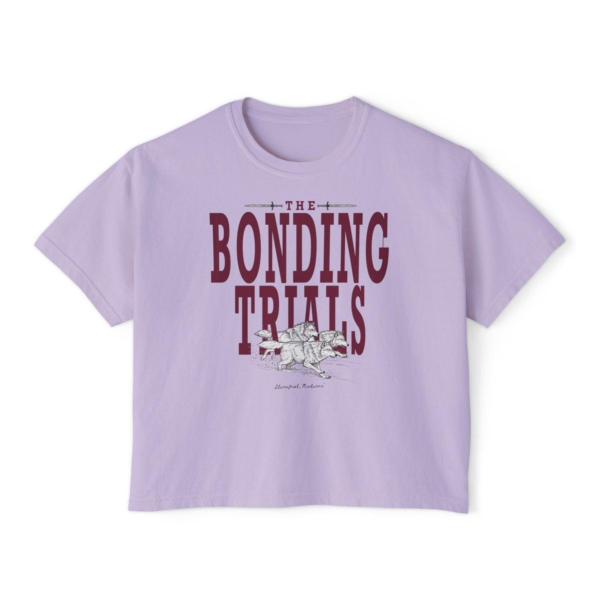 thtgrlreads Wolves of Ruin collection features a lavender Comfort Colors crop top with vintage wash, bold maroon "The Bonding Trials" text, and a detailed wolf graphic.
