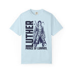 Kindred's Curse Saga tee by thtgrlreads featuring a vintage wash Comfort Colors graphic tee in light blue with bold black print of a fantasy character and text "Luther Prince of Lumnos," part of official licensed bookish apparel collections.