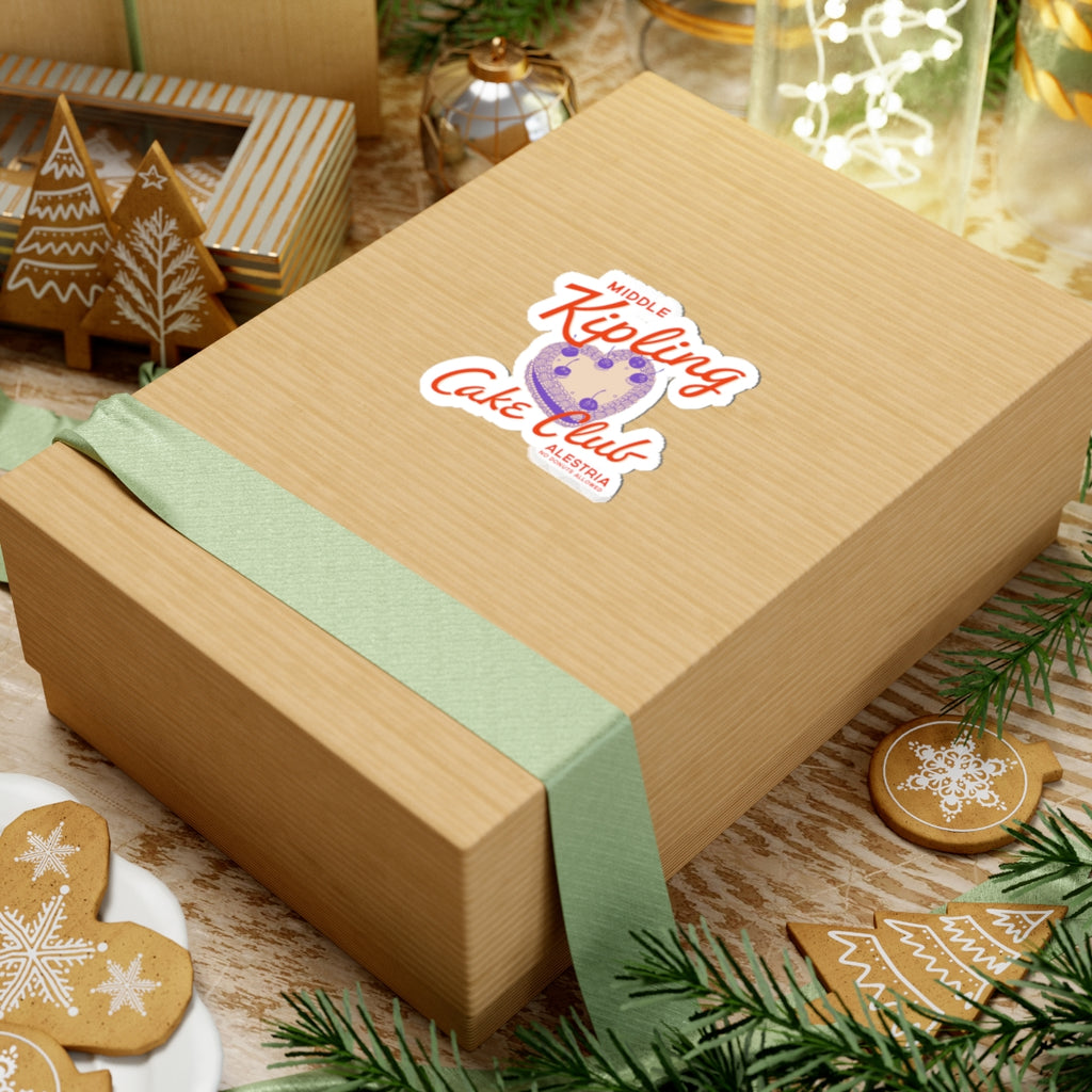 Thtgrlreads Ruthless Boys of the Zodiac collection sticker featuring a vintage-style cake club graphic on a kraft gift box with festive holiday decor and green ribbon accents.