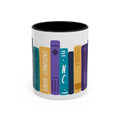 White ceramic mug with black interior featuring colorful, stylized book spines including one labeled "Emotionally Ruined" in a playful design by thtgrlreads.
