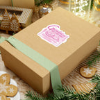 Zodiac Academy themed Geraldine's Bagels sticker from thtgrlreads displayed on a kraft gift box with a pale green ribbon, surrounded by festive gingerbread cookies and holiday decor.