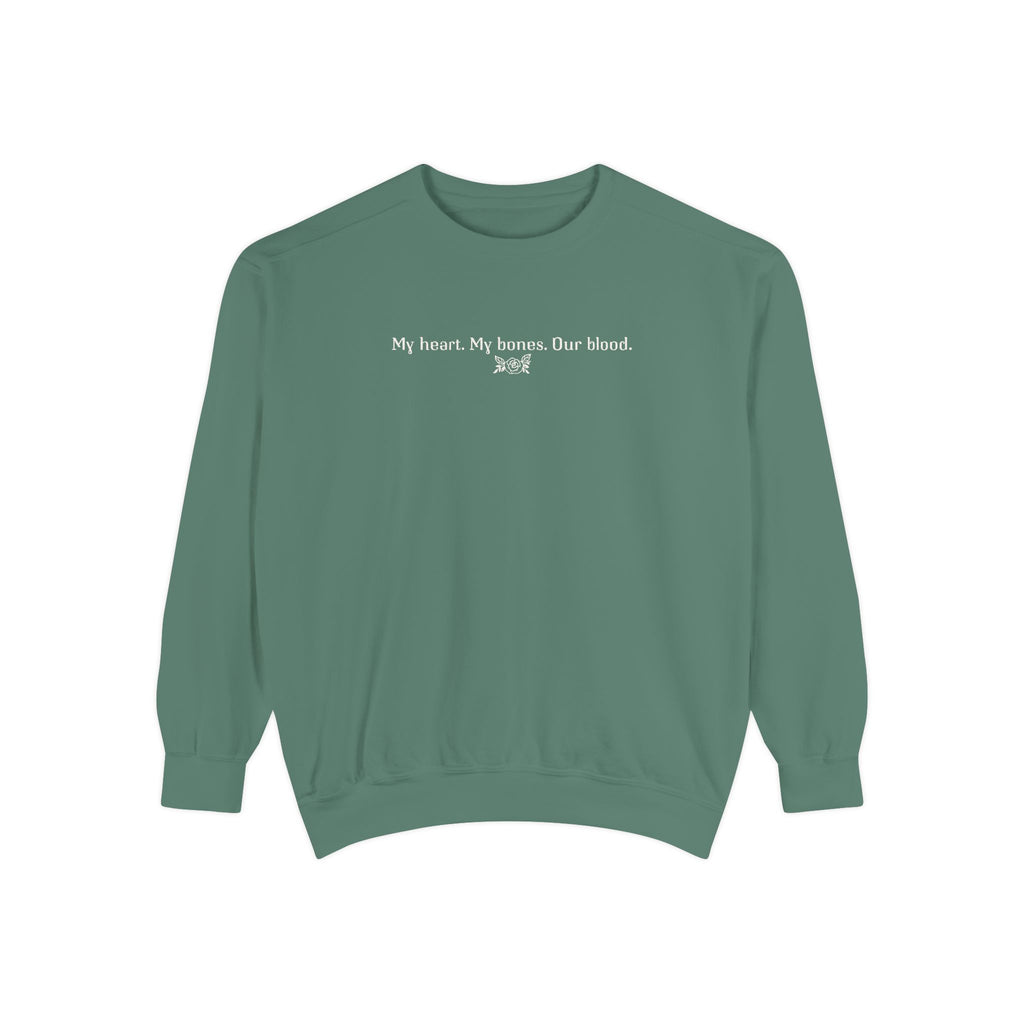 Thtgrlreads oversized crewneck from The Poison Daughter collection featuring a sage green vintage wash Comfort Colors base with white text reading "My heart. My bones. Our blood." in a simple font.