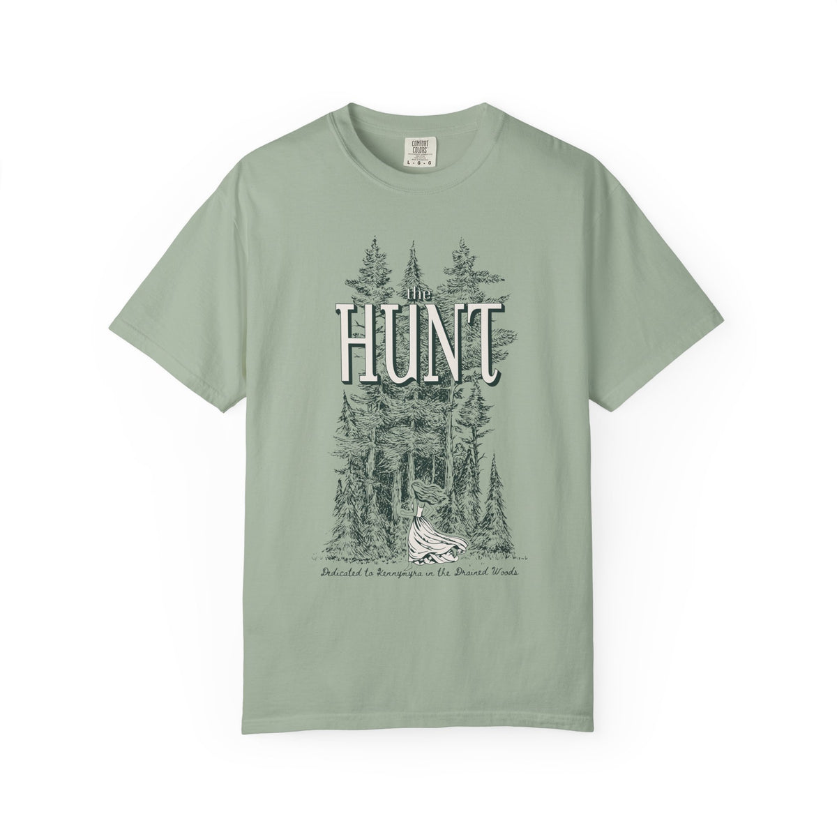 Thtgrlreads The Poison Daughter collection features a sage green Comfort Colors graphic tee with vintage wash and a detailed forest scene surrounding the large "HUNT" text in a classic font.