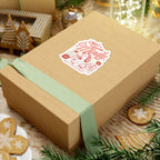 Sticker themed around Ruthless Boys of the Zodiac from thtgrlreads, featuring a vintage-style red illustration and lettering, displayed on a gift box with holiday decor accents.
