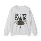 Light gray Koen's Cabin crewneck sweatshirt featuring a mountain cabin and pine trees from Thtgrlreads Ali Hazelwood collection