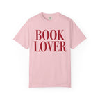 Comfort Colors vintage-washed pink graphic tee from thtgrlreads featuring bold red serif "BOOK LOVER" text, part of the Tees collection for bookish apparel fans.