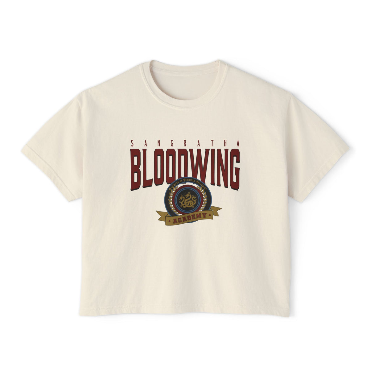 A cream-colored unisex Comfort Colors cropped t-shirt featuring a vintage wash and bold Bloodwing Academy graphic text with a circular emblem in maroon and gold, thtgrlreads.
