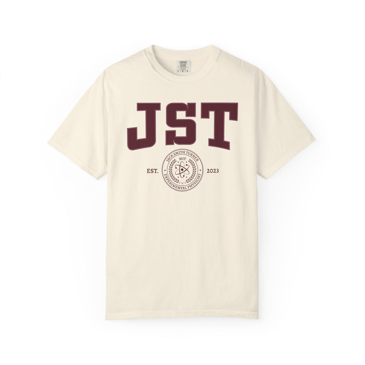 Cream Comfort Colors graphic tee featuring bold burgundy JST lettering and a circular MIT seal design, from the Ali Hazelwood Tees collection by Printify