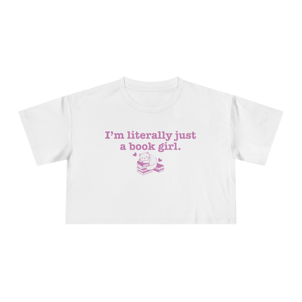 thtgrlreads officially licensed bookish apparel features this Printify white Comfort Colors crop top with vintage wash, soft fabric, and a purple graphic saying "I'm literally just a book girl" above a stack of books illustration, part of the Tees collection.