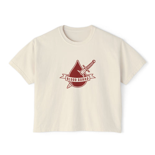 Thtgrlreads Bloodwing Academy crop top featuring a vintage-wash comfort colors fabric with a bold graphic of a blood drop and sword and "Blood Guard" banner in deep red, part of officially licensed bookish apparel collections.