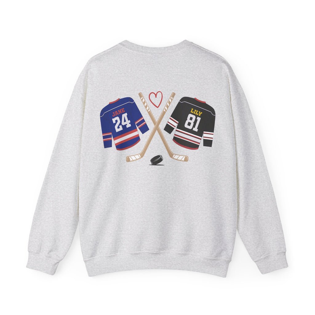 A thtgrlreads light gray Comfort Colors oversized crewneck sweatshirt from the Hockey Romance collection featuring a vintage graphic of crossed hockey sticks, a puck, and jerseys labeled "Jane 24" and "Lily 81" with a red heart above.
