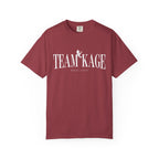 Comfort Colors graphic tee by thtgrlreads featuring Bloodwing Academy from the official collection, in a vintage-washed deep red with bold white "Team Kage" text and a small dragon graphic.