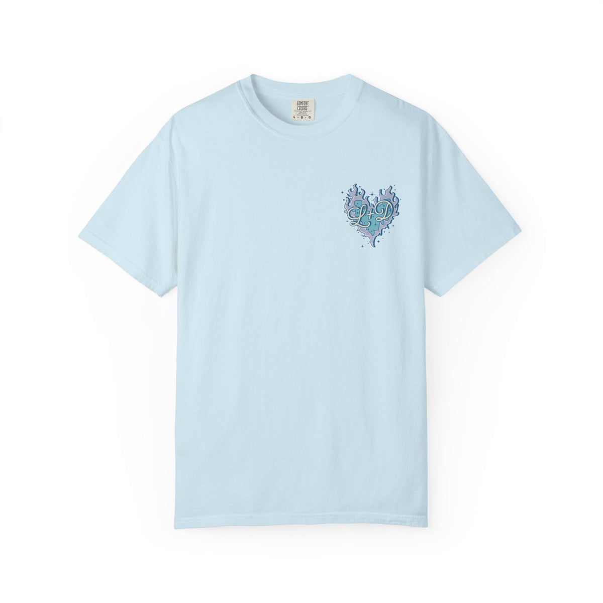 thtgrlreads light blue Comfort Colors graphic tee featuring a small, intricate heart-shaped design with swirling botanical elements in teal and navy tones on the chest, offering a vintage wash and relaxed unisex fit.