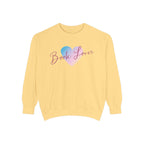 Thtgrlreads cozy oversized crewneck sweatshirt from the Book Bestie collection featuring vintage-washed Comfort Colors fabric and a pastel blue and pink heart with "Book Lover" scripted text.