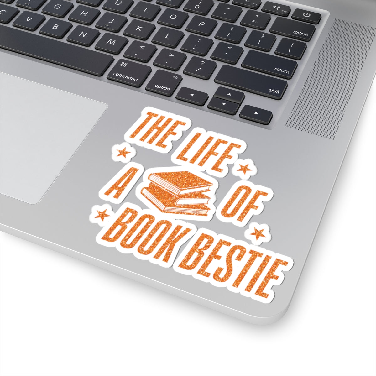 Sticker from thtgrlreads' The Life of a Book Bestie collection featuring vintage orange text and stacked books graphic on a white background, placed on a laptop corner.