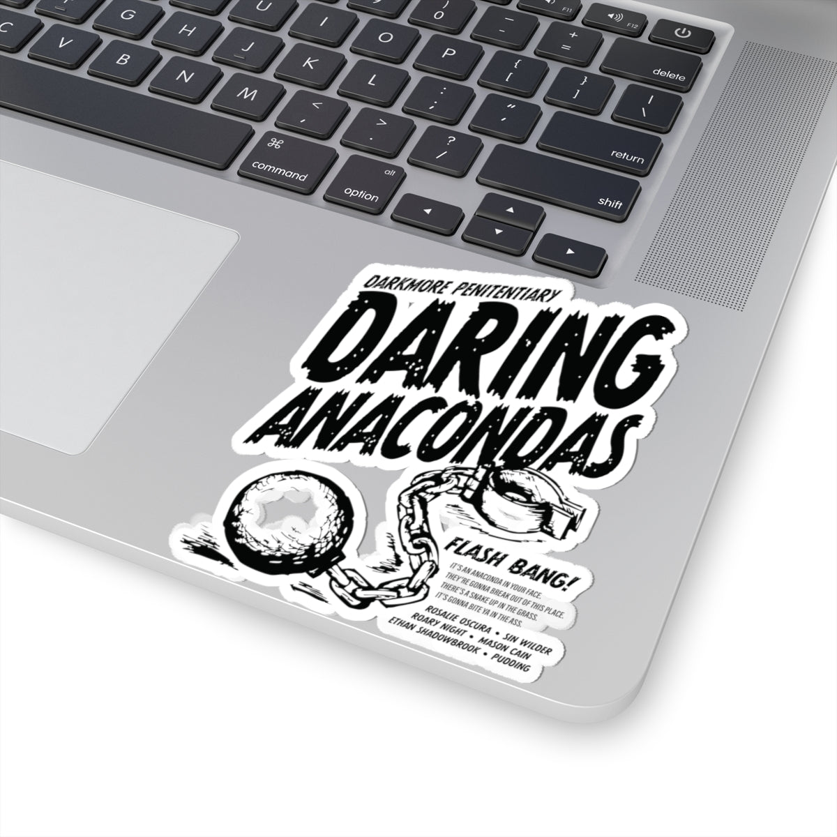 Black and white sticker on a laptop featuring bold, distressed text "Daring Anacondas" with "Darkmore Penitentiary" above, and an illustration of broken handcuffs with a chain.