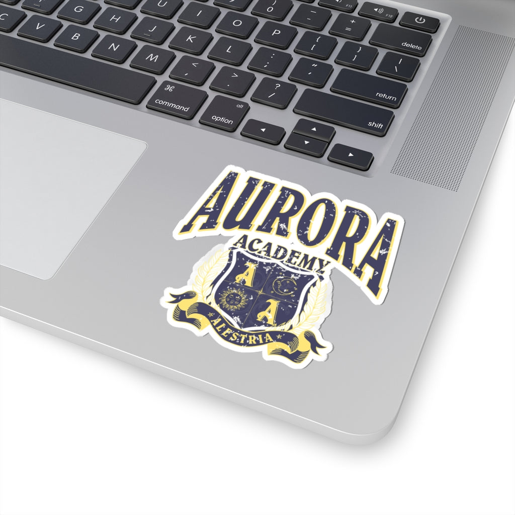 A Ruthless Boys of the Zodiac inspired Aurora Academy sticker from thtgrlreads featuring a vintage-style crest with bold text on a laptop surface, perfect for fans and bookish collectors.