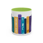 A white ceramic mug with a green interior featuring colorful illustrated book spines, including one labeled "Emotionally Ruined," designed by thtgrlreads for book lovers.